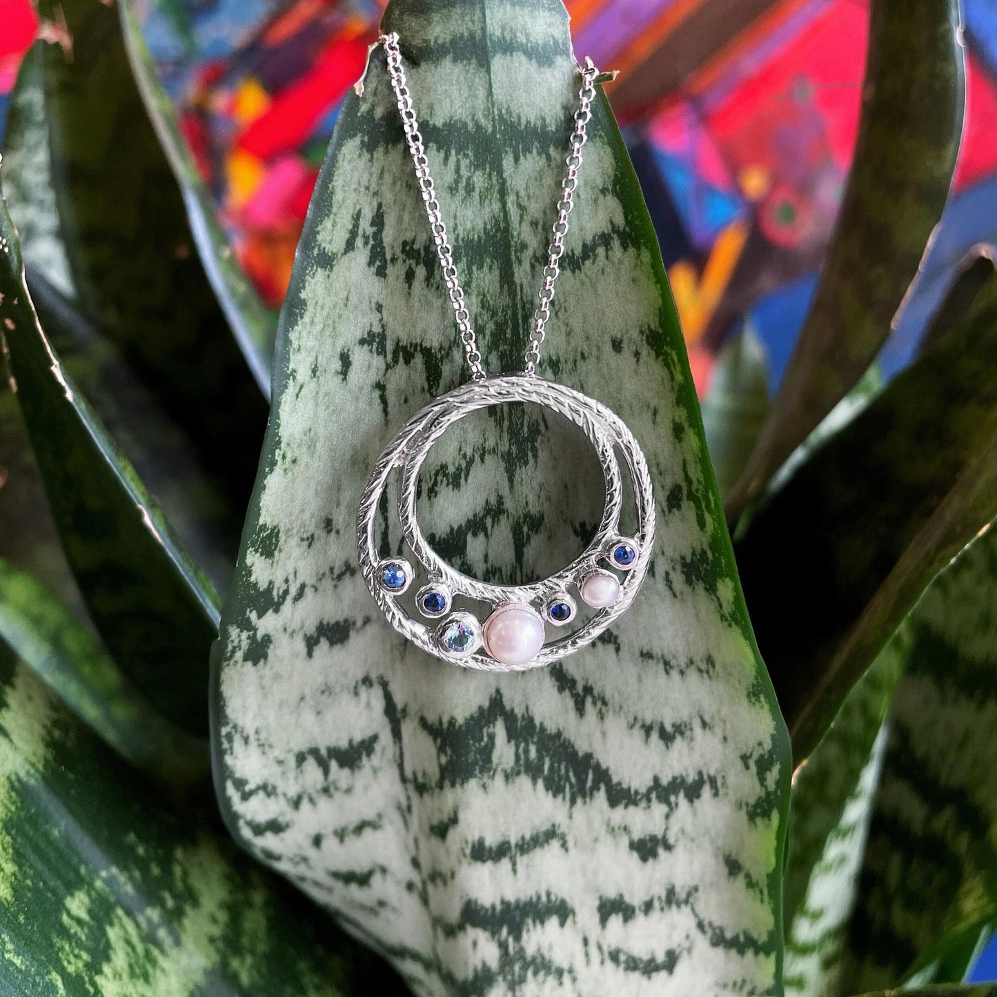 Photo of "Ocean" Pendant in a decorative scene, designed by , available at Plumb Gold & Plumb Silver