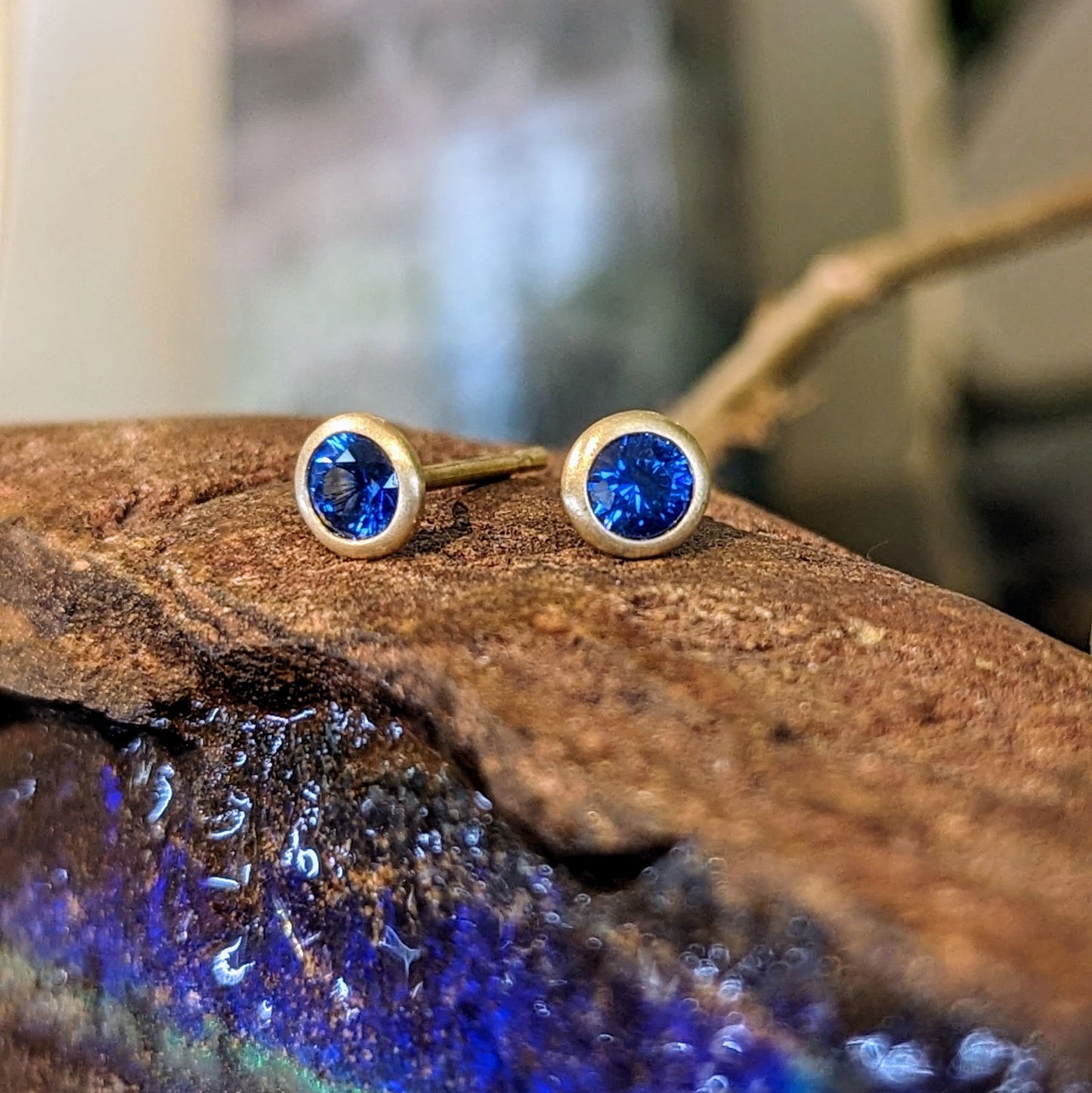 Photo of Petite Sapphire Studs in a decorative scene, designed by , available at Plumb Gold & Plumb Silver