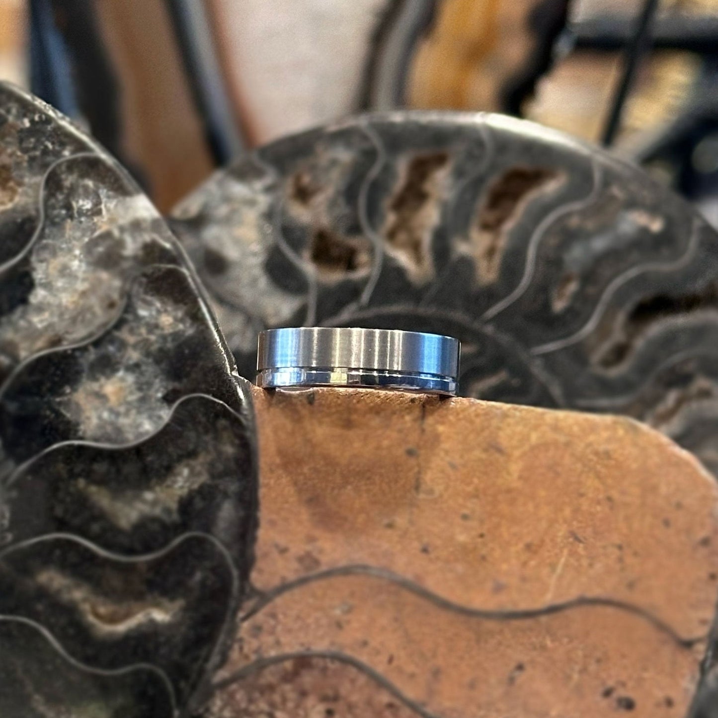 Photo of Titanium Polished and Brushed Grooved Band in a decorative scene, designed by , available at Plumb Gold & Plumb Silver