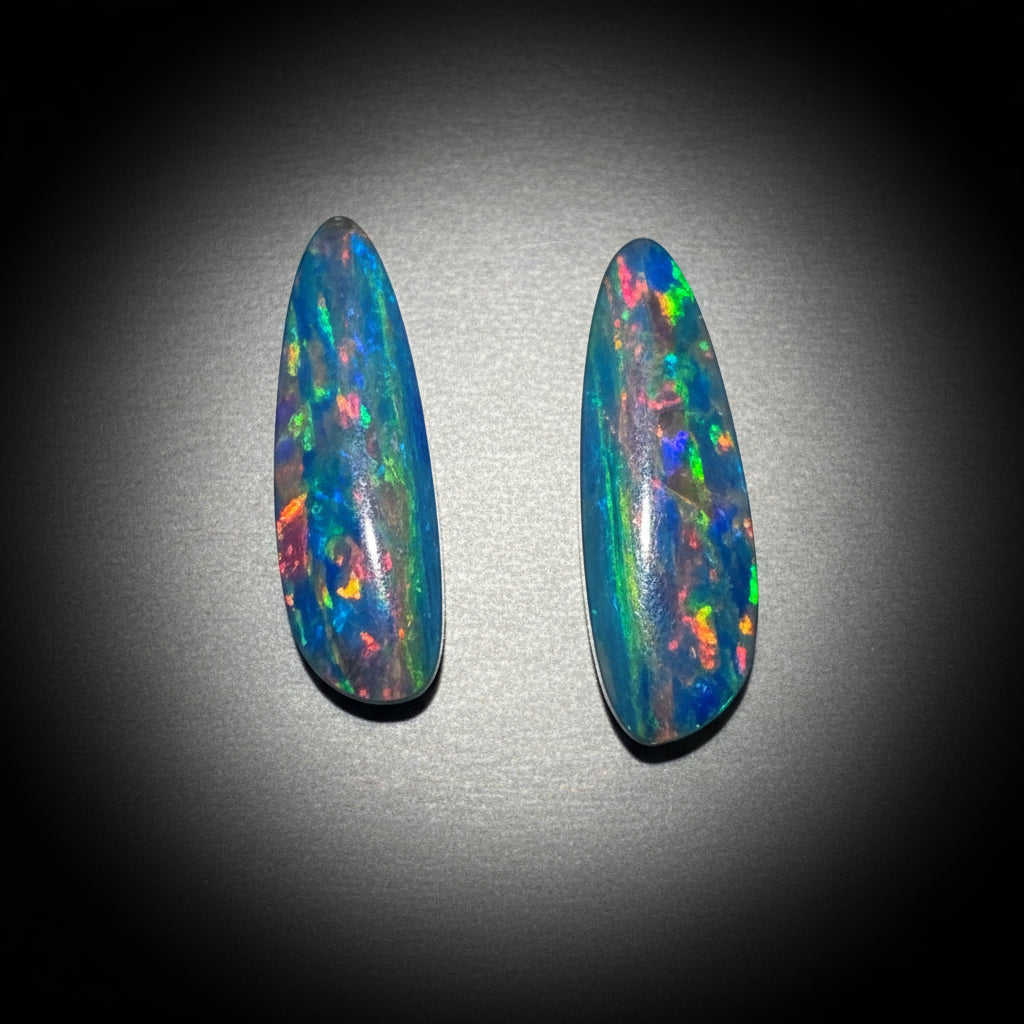 two opals on a black and silver background
