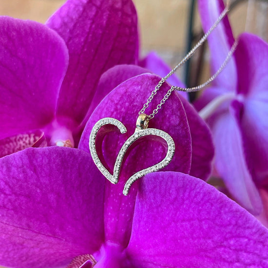 Photo of Abstract Diamond Heart Necklace in a decorative scene, designed by , available at Plumb Gold & Plumb Silver