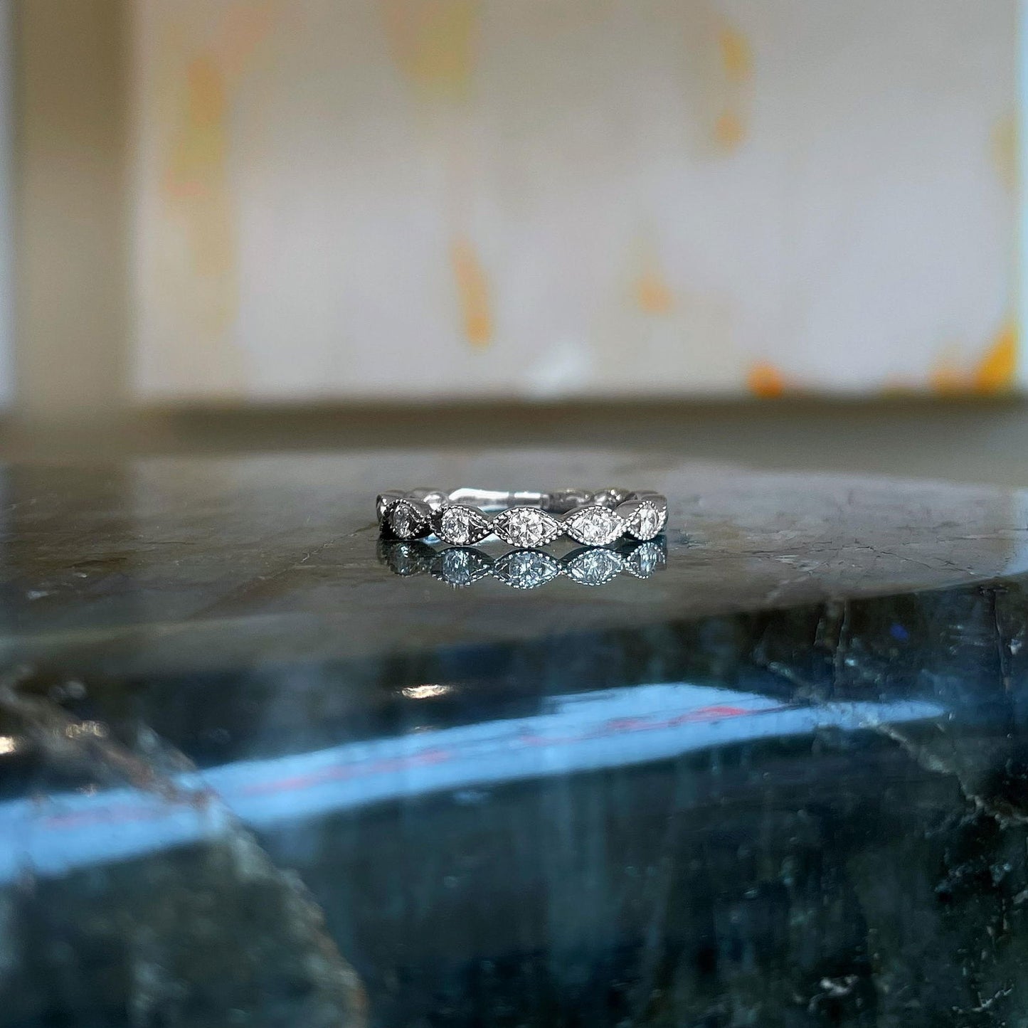 Photo of "Alicia" Twist Diamond Band in a decorative scene, designed by , available at Plumb Gold & Plumb Silver