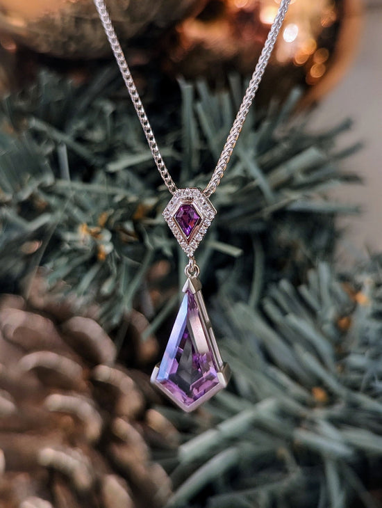 Photo of Amethyst and Pink Sapphire Pendant in a decorative scene, designed by , available at Plumb Gold & Plumb Silver