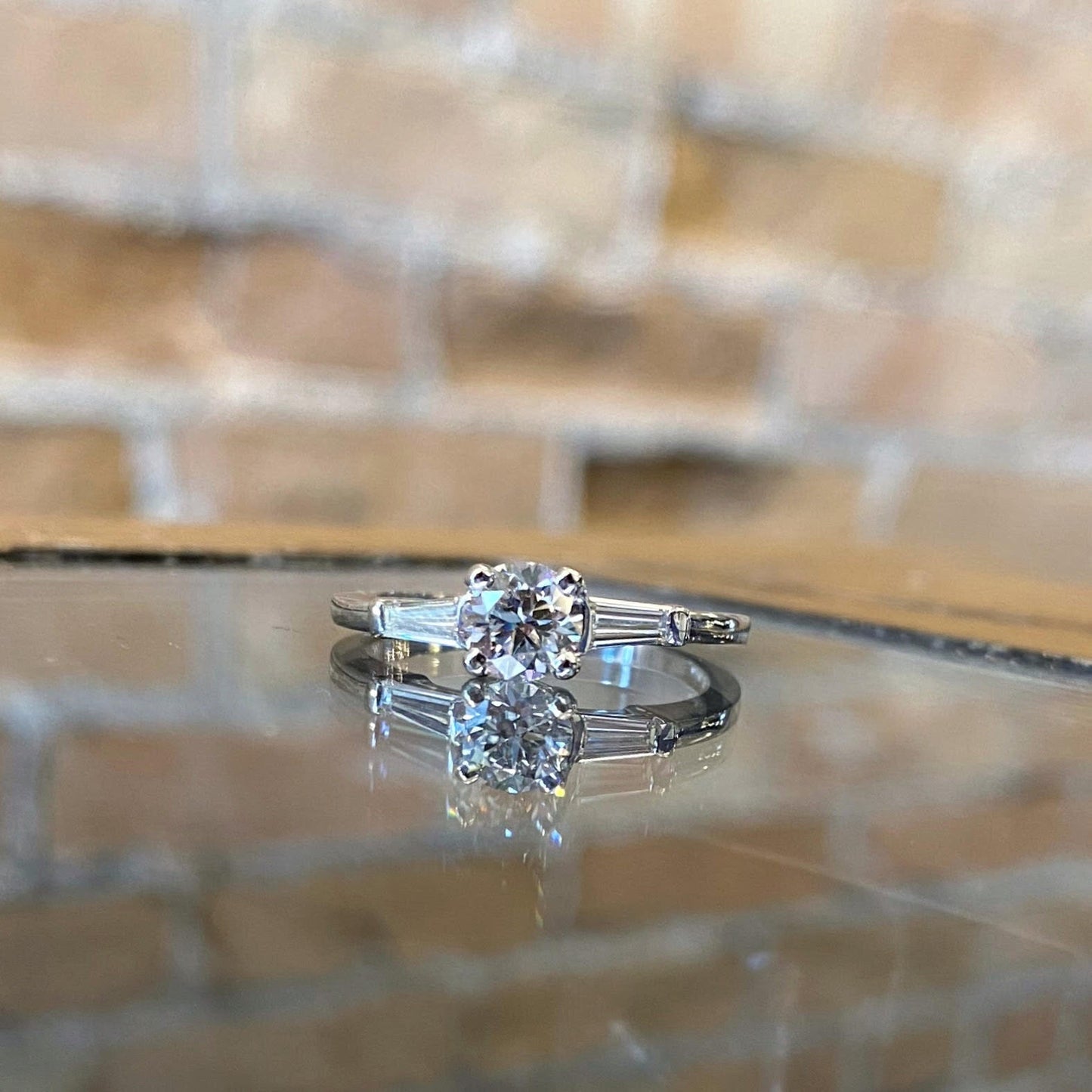 Photo of Baguette Side-stones Engagement Ring in a decorative scene, designed by , available at Plumb Gold & Plumb Silver