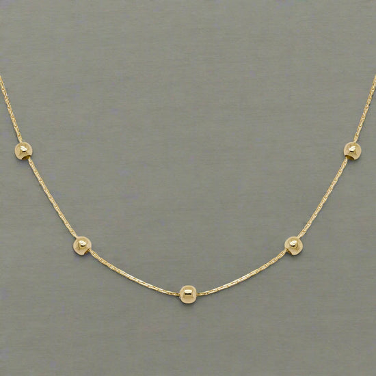 Photo of Beaded Station Chain in a decorative scene, designed by , available at Plumb Gold & Plumb Silver