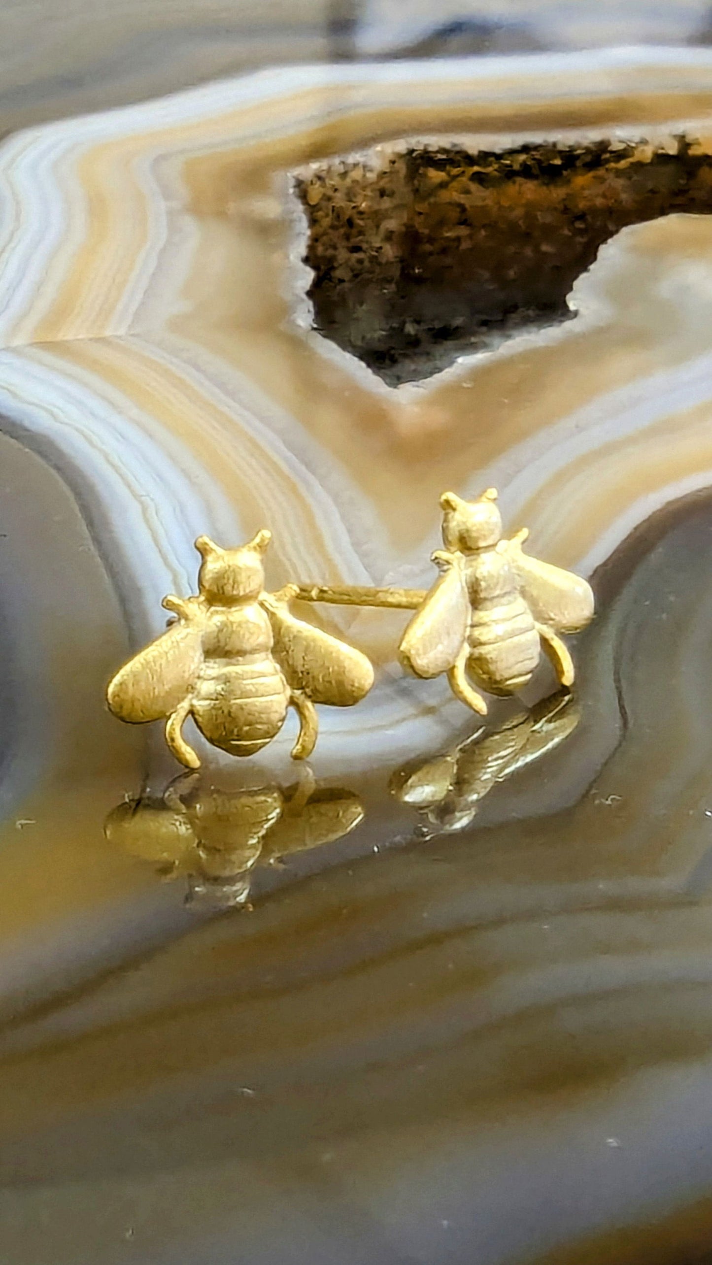 Photo of Bee Stud Earrings in a decorative scene, designed by , available at Plumb Gold & Plumb Silver