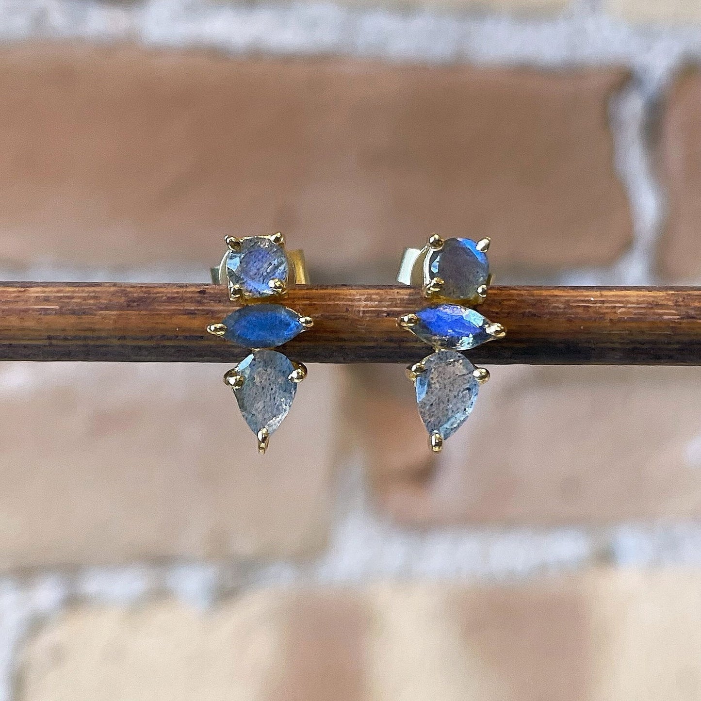 Photo of “Bella” Labradorite Studs in a decorative scene, designed by , available at Plumb Gold & Plumb Silver