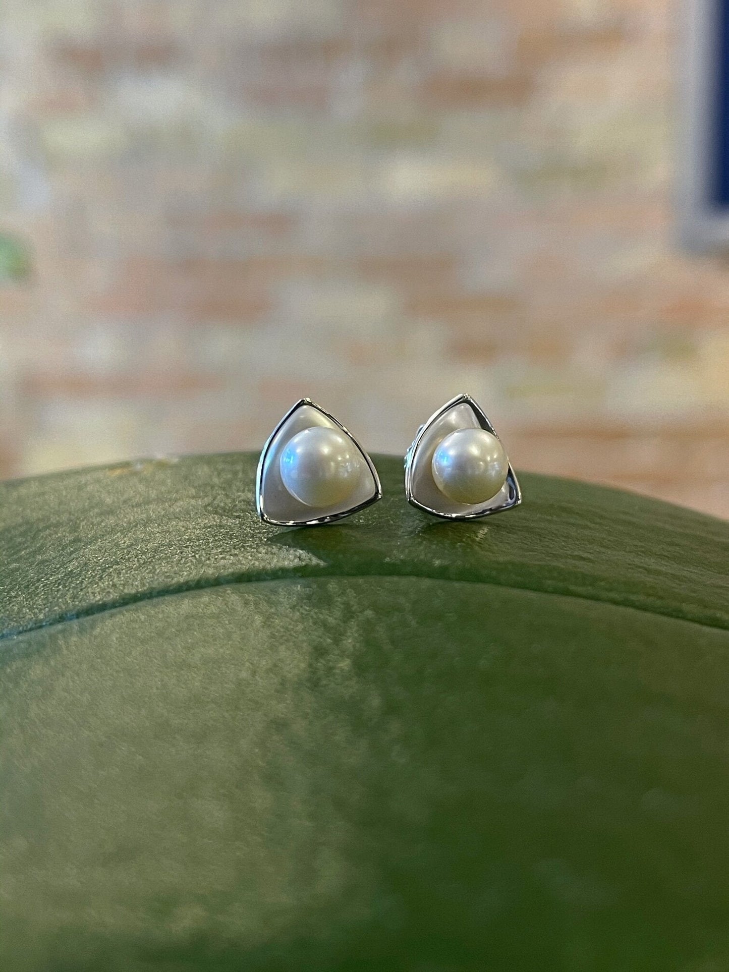 Photo of "Birdie" Pearl Studs in a decorative scene, designed by , available at Plumb Gold & Plumb Silver