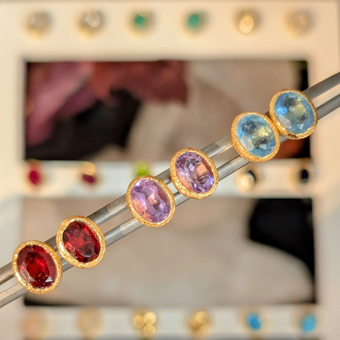 Photo of Birthstone Earrings by Jorge in a decorative scene, designed by -, available at Plumb Gold & Plumb Silver