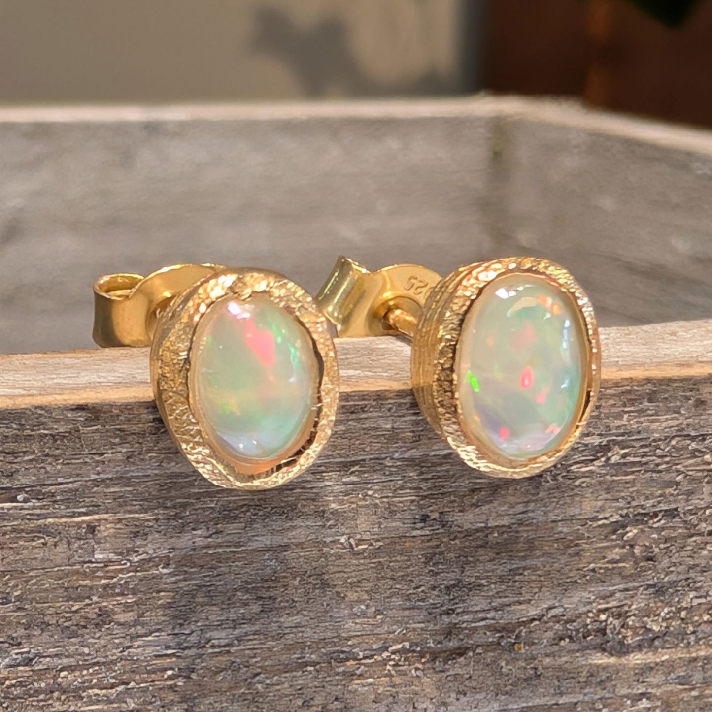 Photo of Birthstone Earrings by Jorge in a decorative scene, designed by -, available at Plumb Gold & Plumb Silver