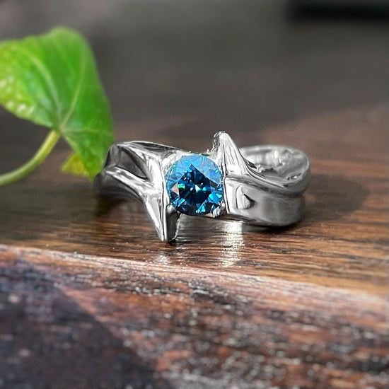 Photo of Blue Diamond Ring in a decorative scene, designed by , available at Plumb Gold & Plumb Silver