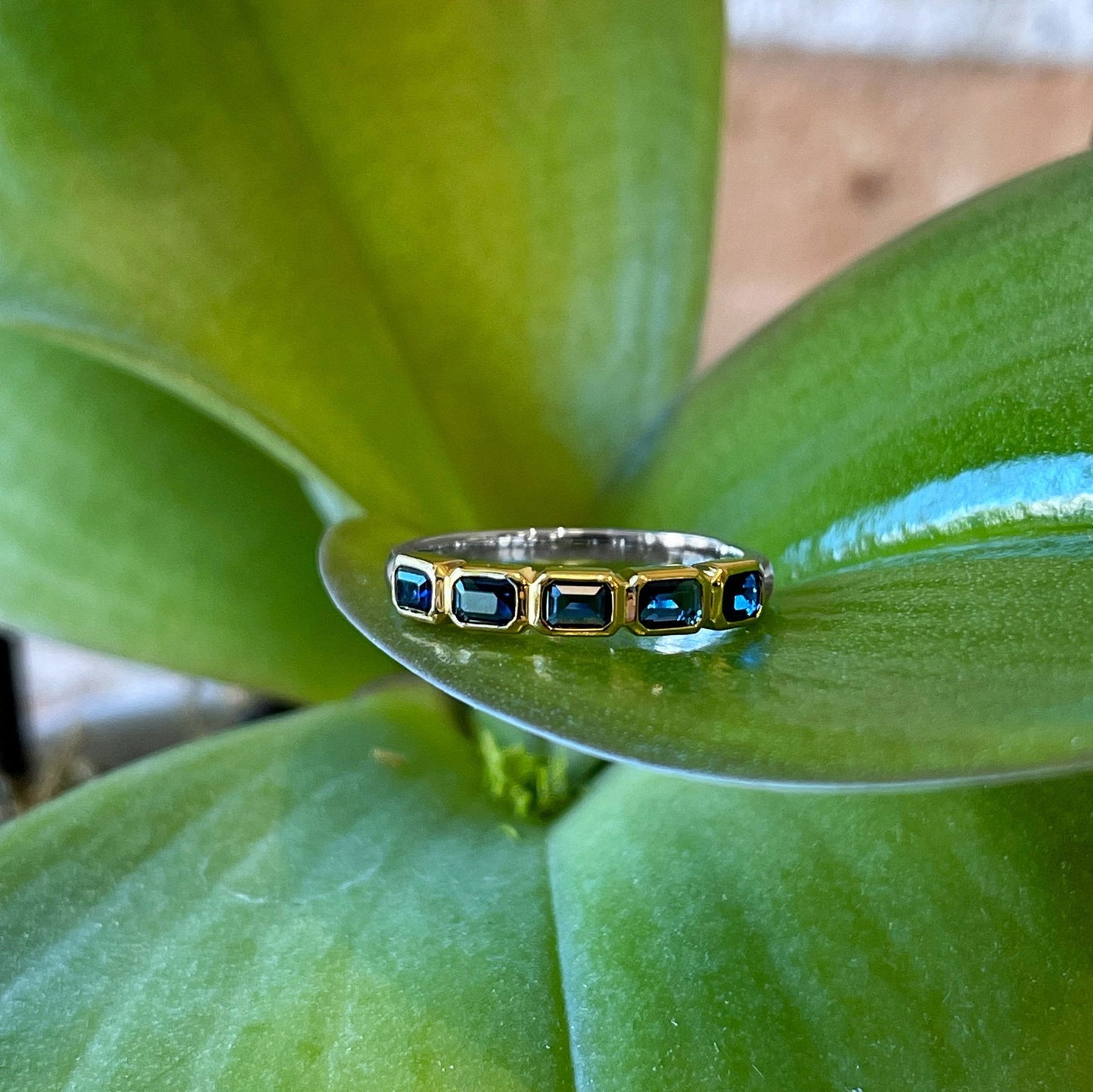 Photo of Blue Emerald-Cut Cubic Zirconia Ring in a decorative scene, designed by , available at Plumb Gold & Plumb Silver