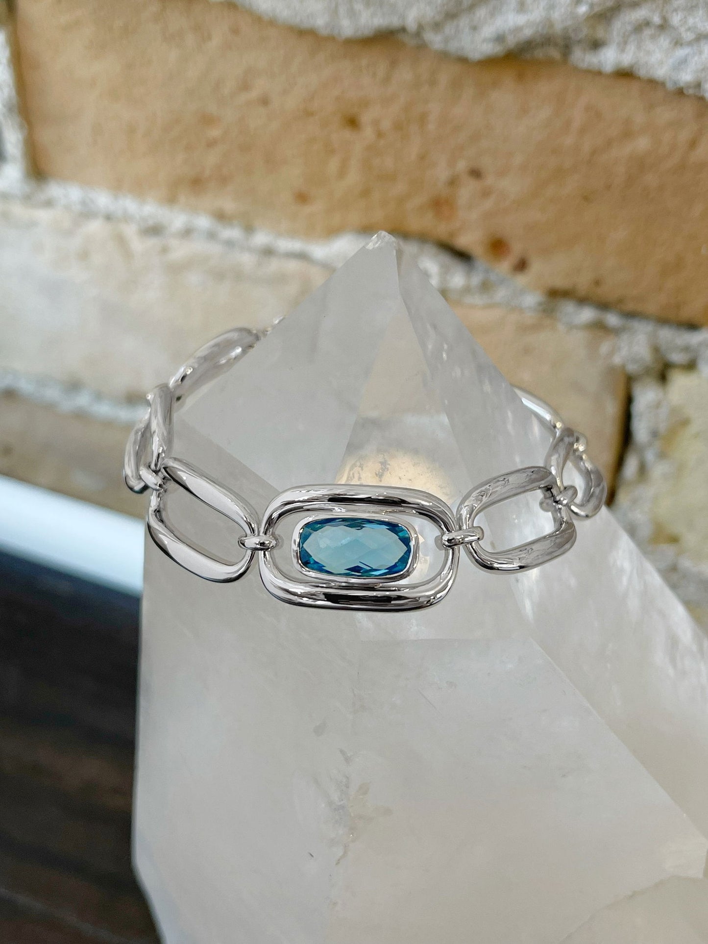 Photo of Blue Topaz Chain Bracelet in a decorative scene, designed by , available at Plumb Gold & Plumb Silver
