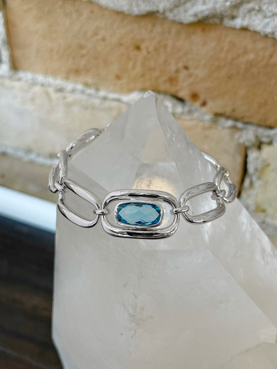 Photo of Blue Topaz Chain Bracelet in a decorative scene, designed by , available at Plumb Gold & Plumb Silver