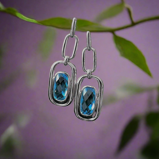 Photo of Blue Topaz Chain Earrings in a decorative scene, designed by , available at Plumb Gold & Plumb Silver