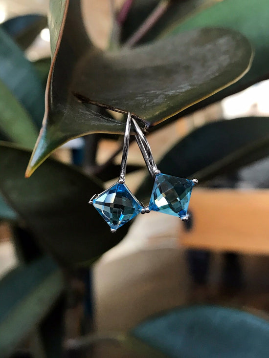 Photo of Blue Topaz Dangles in a decorative scene, designed by , available at Plumb Gold & Plumb Silver