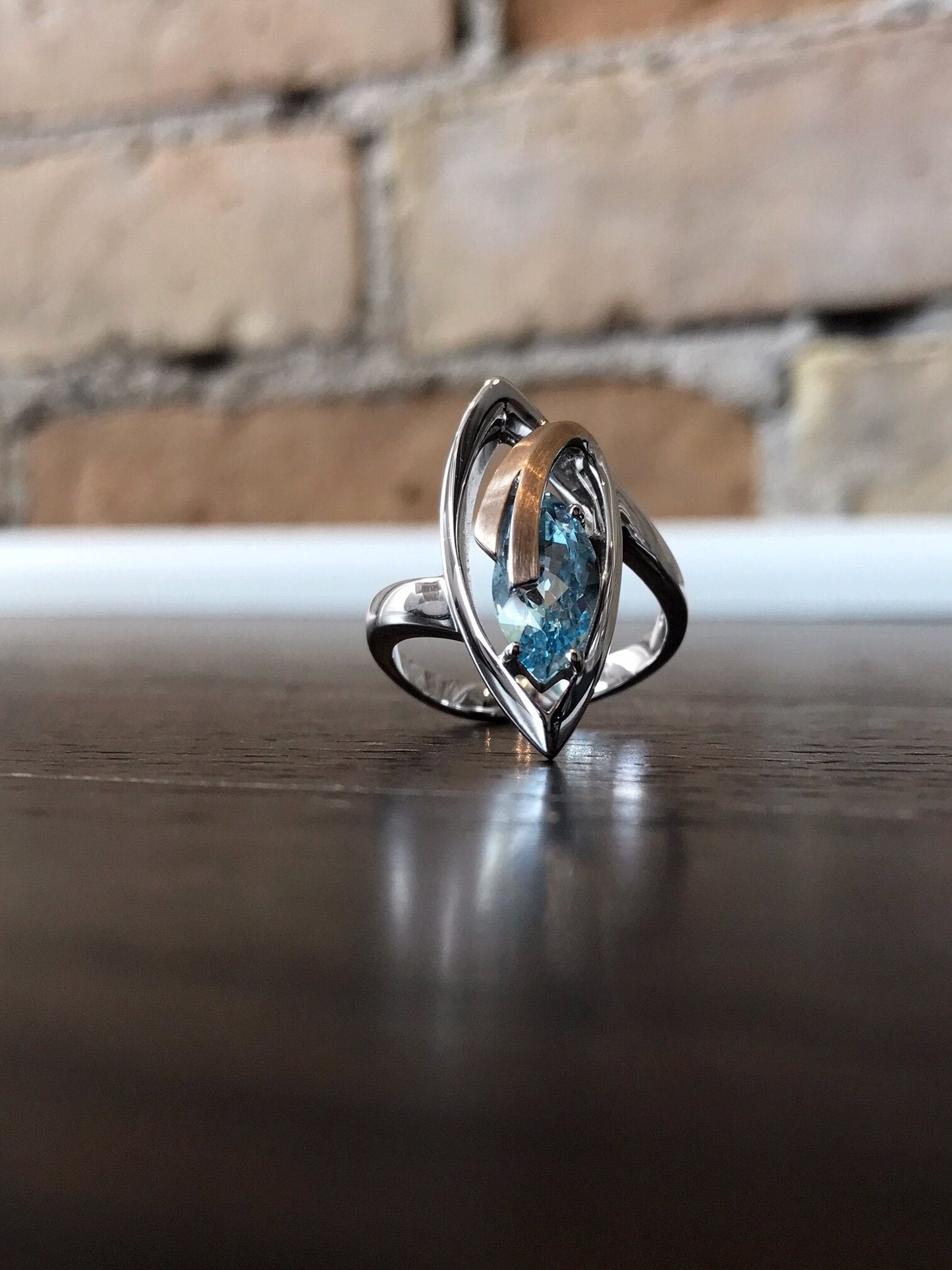 Photo of Blue Topaz Marquise Ring in a decorative scene, designed by , available at Plumb Gold & Plumb Silver