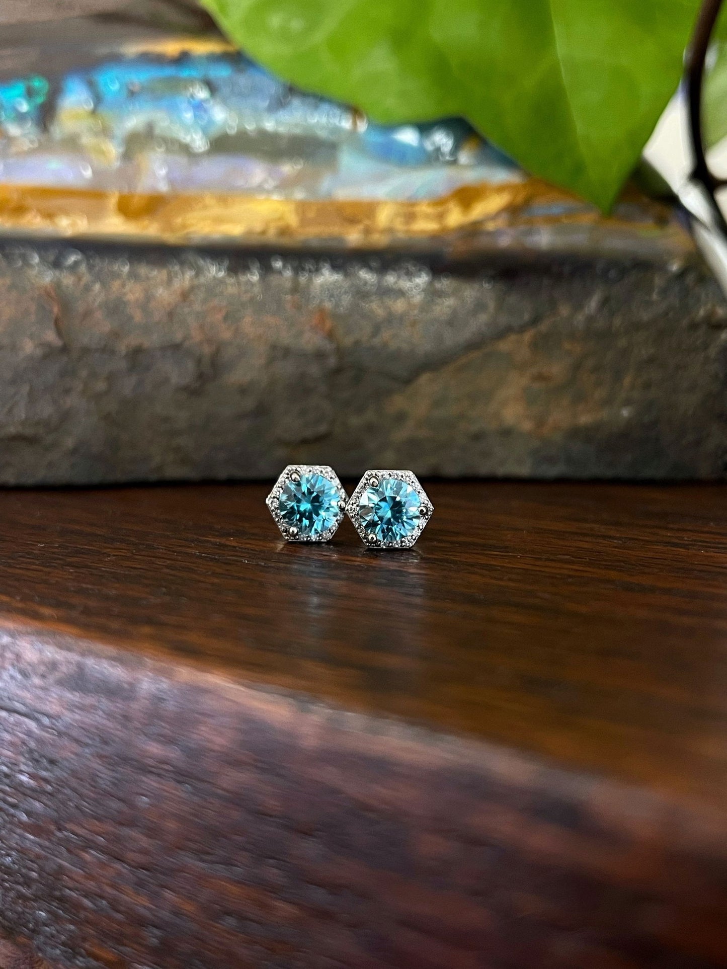 Photo of Blue Zircon Hexagon Studs in a decorative scene, designed by , available at Plumb Gold & Plumb Silver