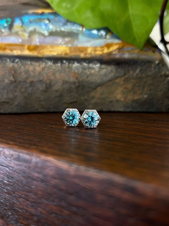 Photo of Blue Zircon Hexagon Studs in a decorative scene, designed by , available at Plumb Gold & Plumb Silver