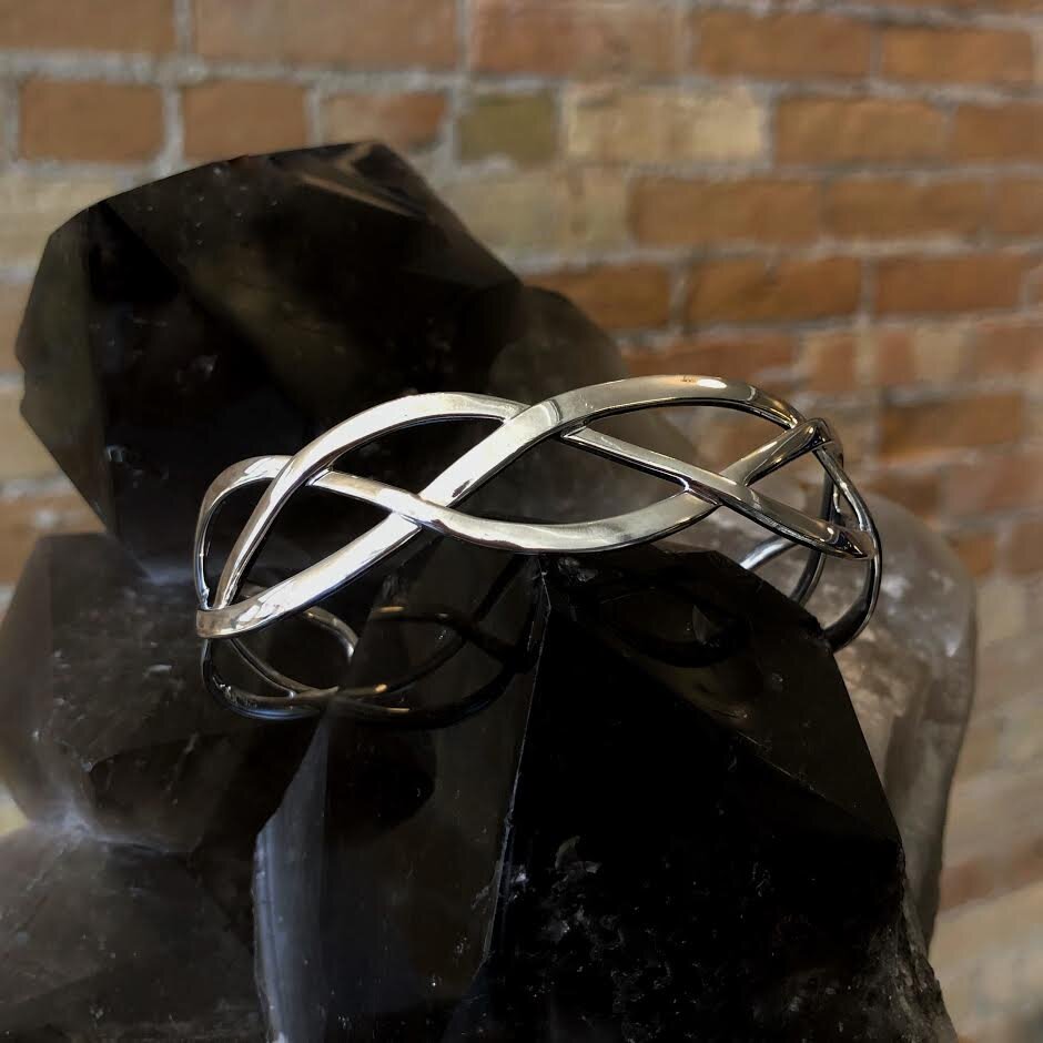 Photo of Braided Cuff Bracelet in a decorative scene, designed by , available at Plumb Gold & Plumb Silver