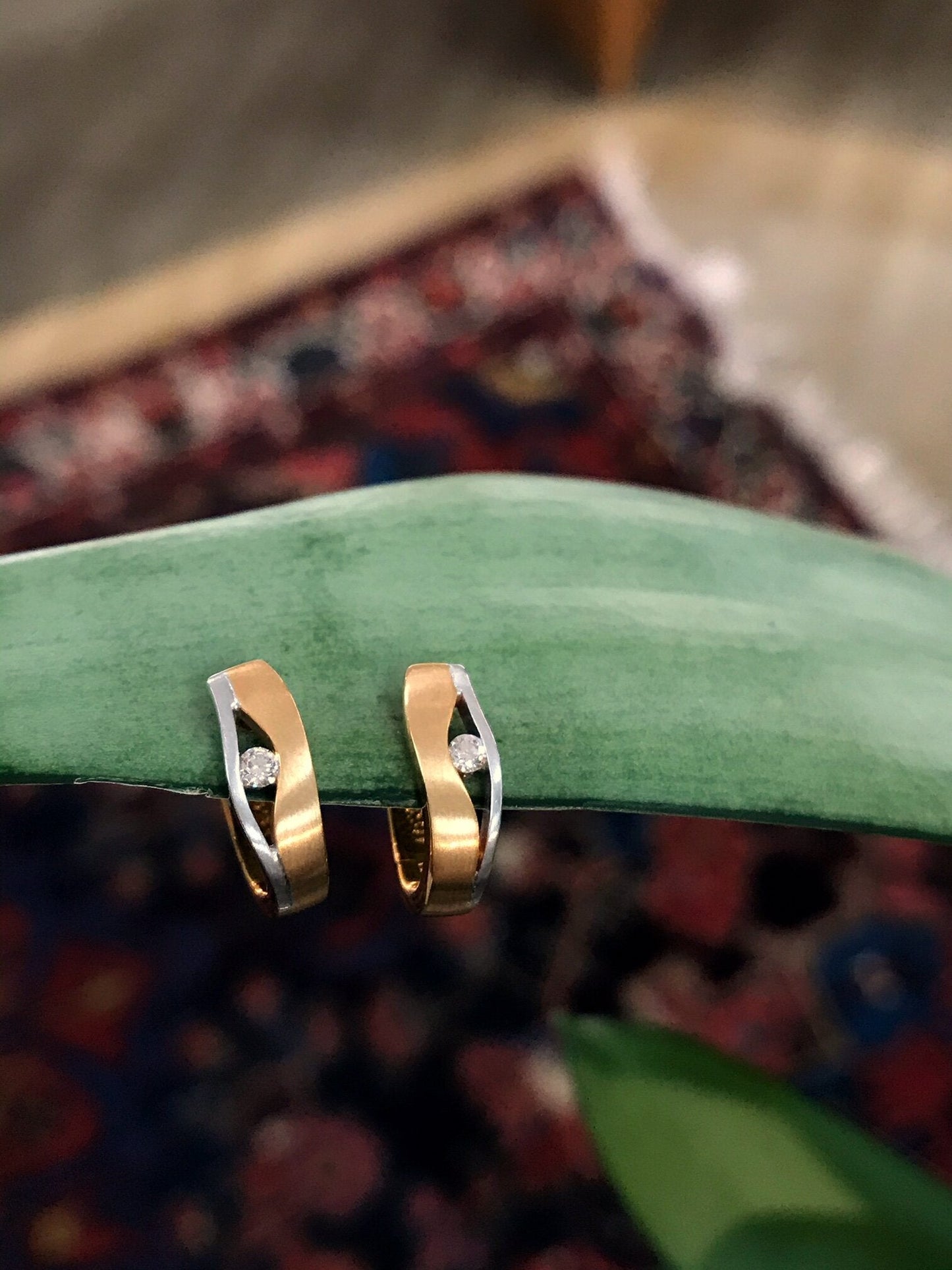 Photo of Breuning Hidden Diamond Huggies in a decorative scene, designed by , available at Plumb Gold & Plumb Silver