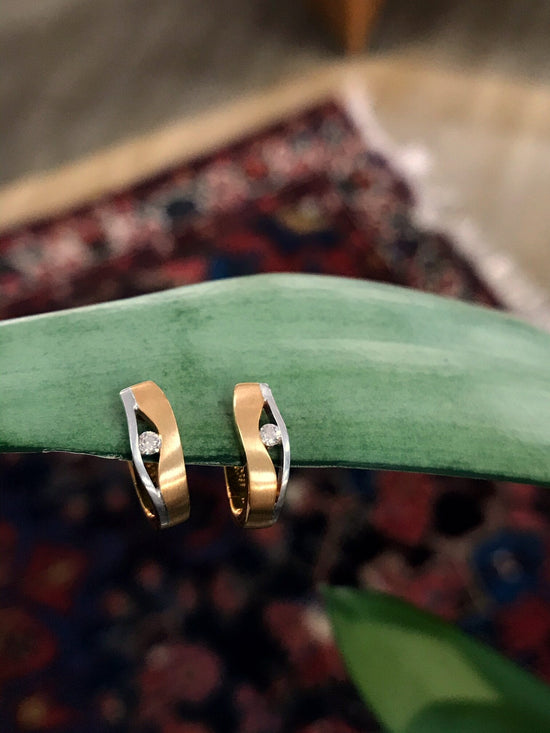 Photo of Breuning Hidden Diamond Huggies in a decorative scene, designed by , available at Plumb Gold & Plumb Silver