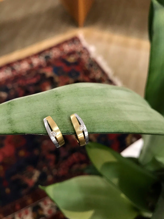 Photo of Breuning Two-Tone Double Line Huggies in a decorative scene, designed by , available at Plumb Gold & Plumb Silver