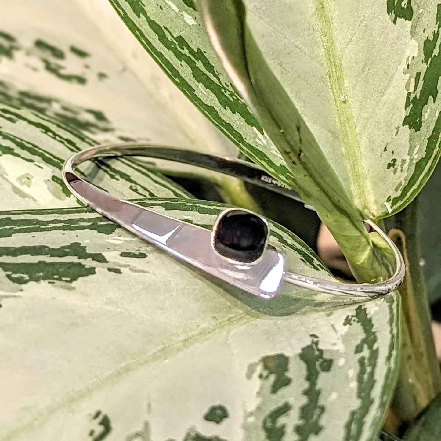 Photo of "Camber" Onyx Bracelet in a decorative scene, designed by , available at Plumb Gold & Plumb Silver