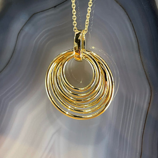 Photo of Cascading Circles Pendant in a decorative scene, designed by , available at Plumb Gold & Plumb Silver