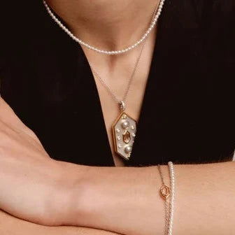 Photo of Celestial Large Hexagon Mother of Pearl Pendant in a decorative scene, designed by , available at Plumb Gold & Plumb Silver