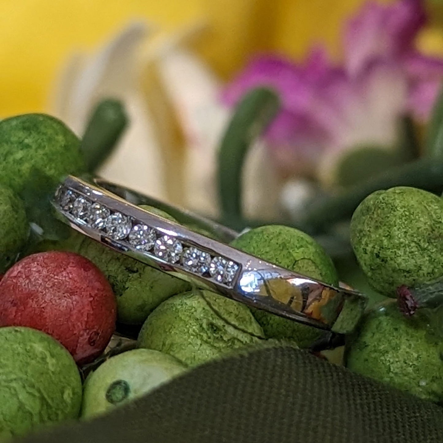 Photo of Channel Set Diamond Ring in a decorative scene, designed by , available at Plumb Gold & Plumb Silver