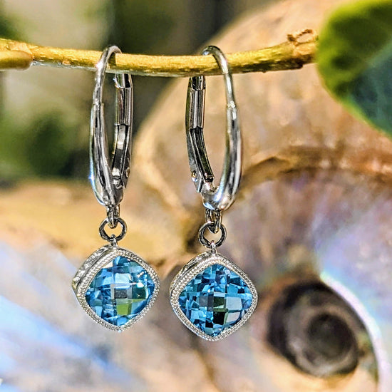 Photo of Checkerboard Blue Topaz Dangles in a decorative scene, designed by , available at Plumb Gold & Plumb Silver
