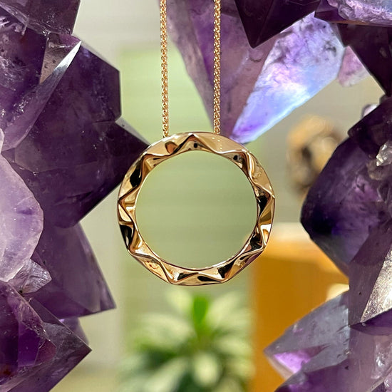 Photo of Chevron Circle Pendant in a decorative scene, designed by , available at Plumb Gold & Plumb Silver