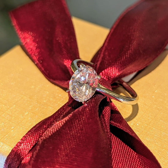 Photo of Classic Oval Solitaire in a decorative scene, designed by , available at Plumb Gold & Plumb Silver