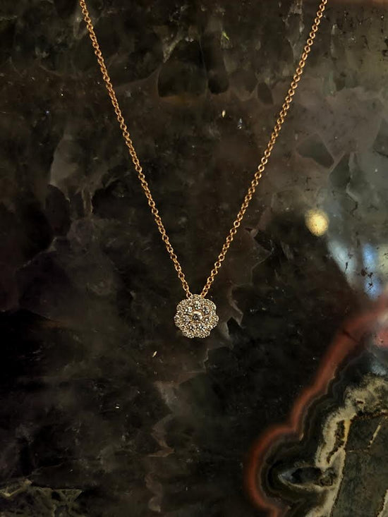Photo of Cluster Flower Necklace in a decorative scene, designed by , available at Plumb Gold & Plumb Silver