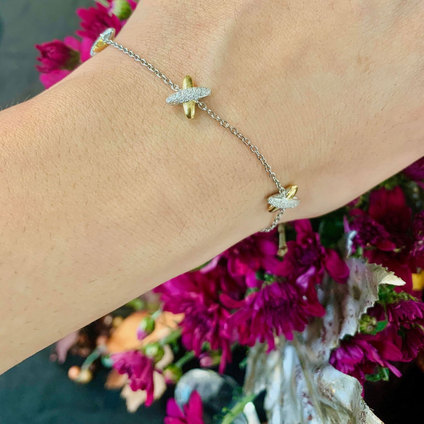Photo of Cross Charm Bracelet in a decorative scene, designed by -, available at Plumb Gold & Plumb Silver