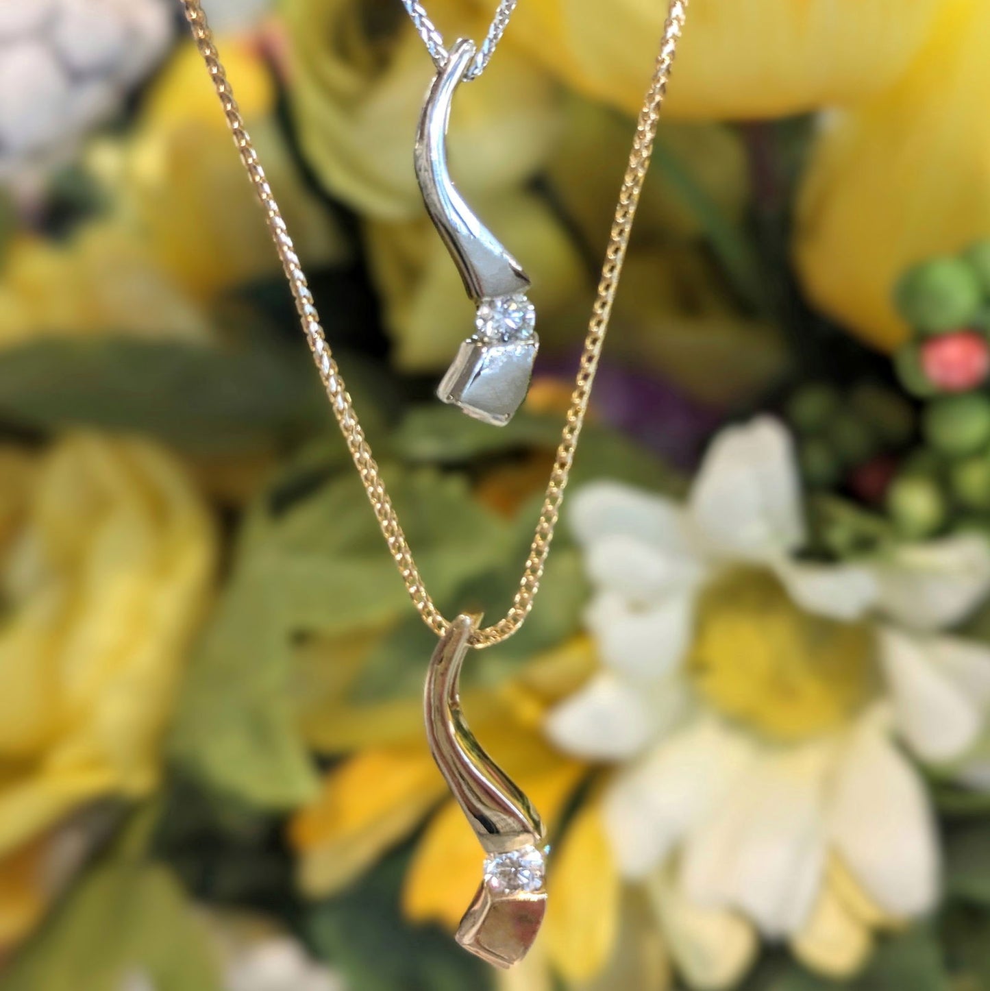 Photo of Curve Diamond Pendant in a decorative scene, designed by , available at Plumb Gold & Plumb Silver
