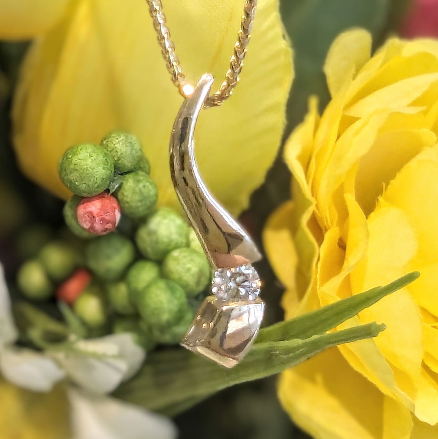 Photo of Curve Diamond Pendant in a decorative scene, designed by , available at Plumb Gold & Plumb Silver