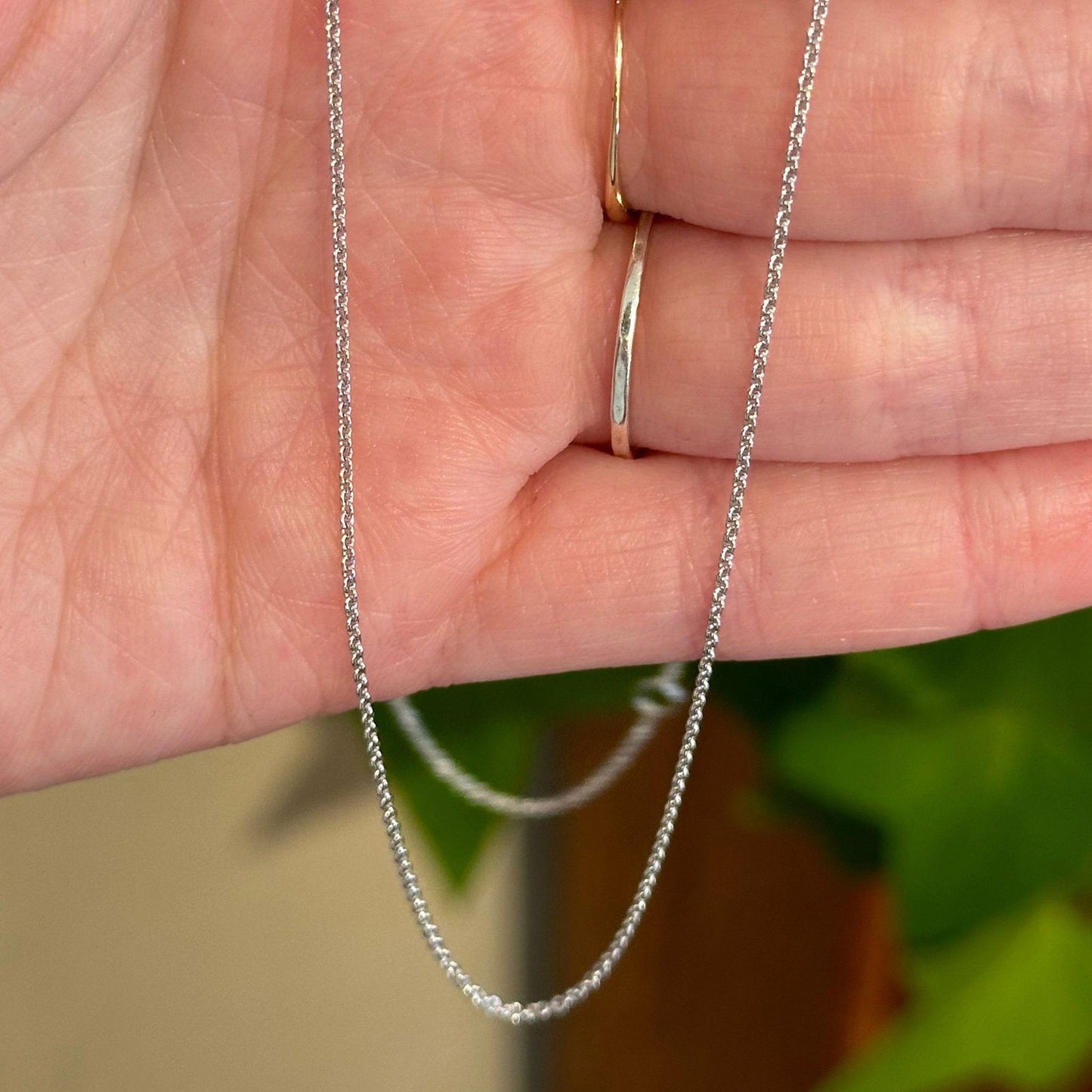 Photo of Dainty Gold Cable Chain in a decorative scene, designed by , available at Plumb Gold & Plumb Silver