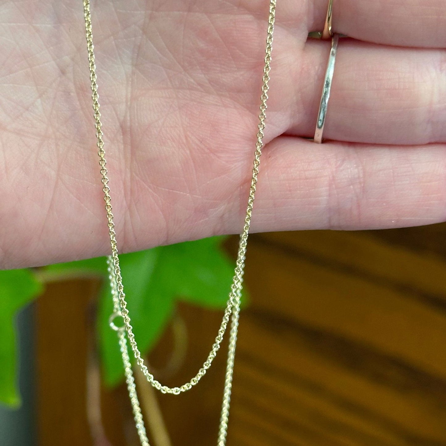 Photo of Dainty Gold Cable Chain in a decorative scene, designed by , available at Plumb Gold & Plumb Silver