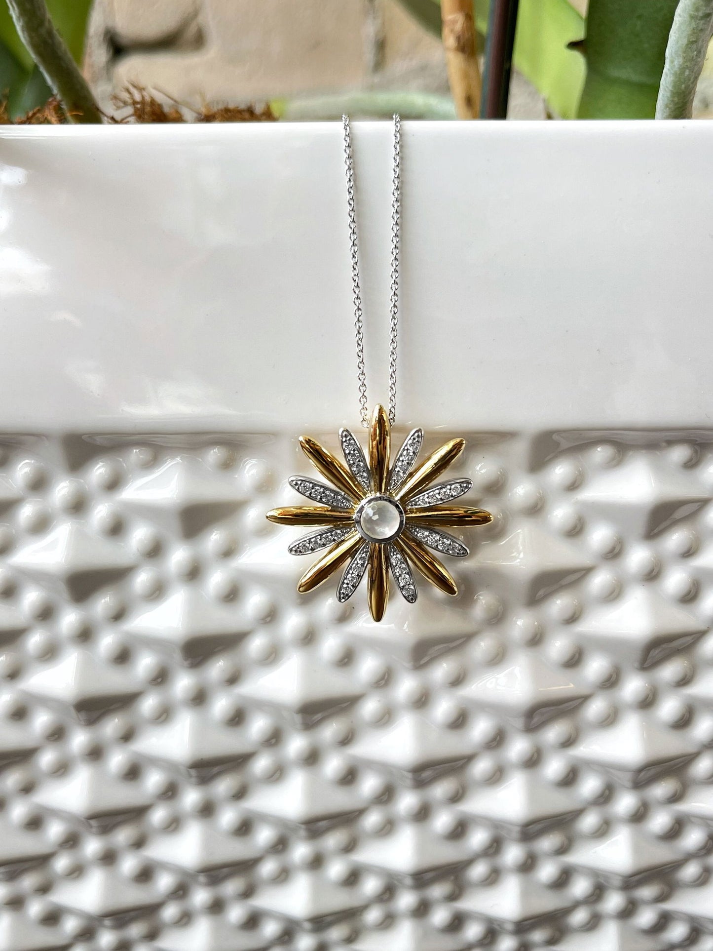 Photo of Daisy Necklace in a decorative scene, designed by , available at Plumb Gold & Plumb Silver