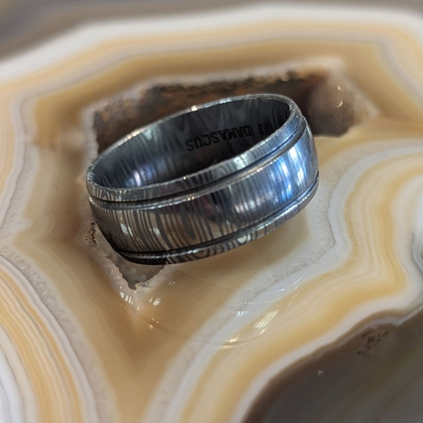 Photo of Damascus Steel Band in a decorative scene, designed by , available at Plumb Gold & Plumb Silver