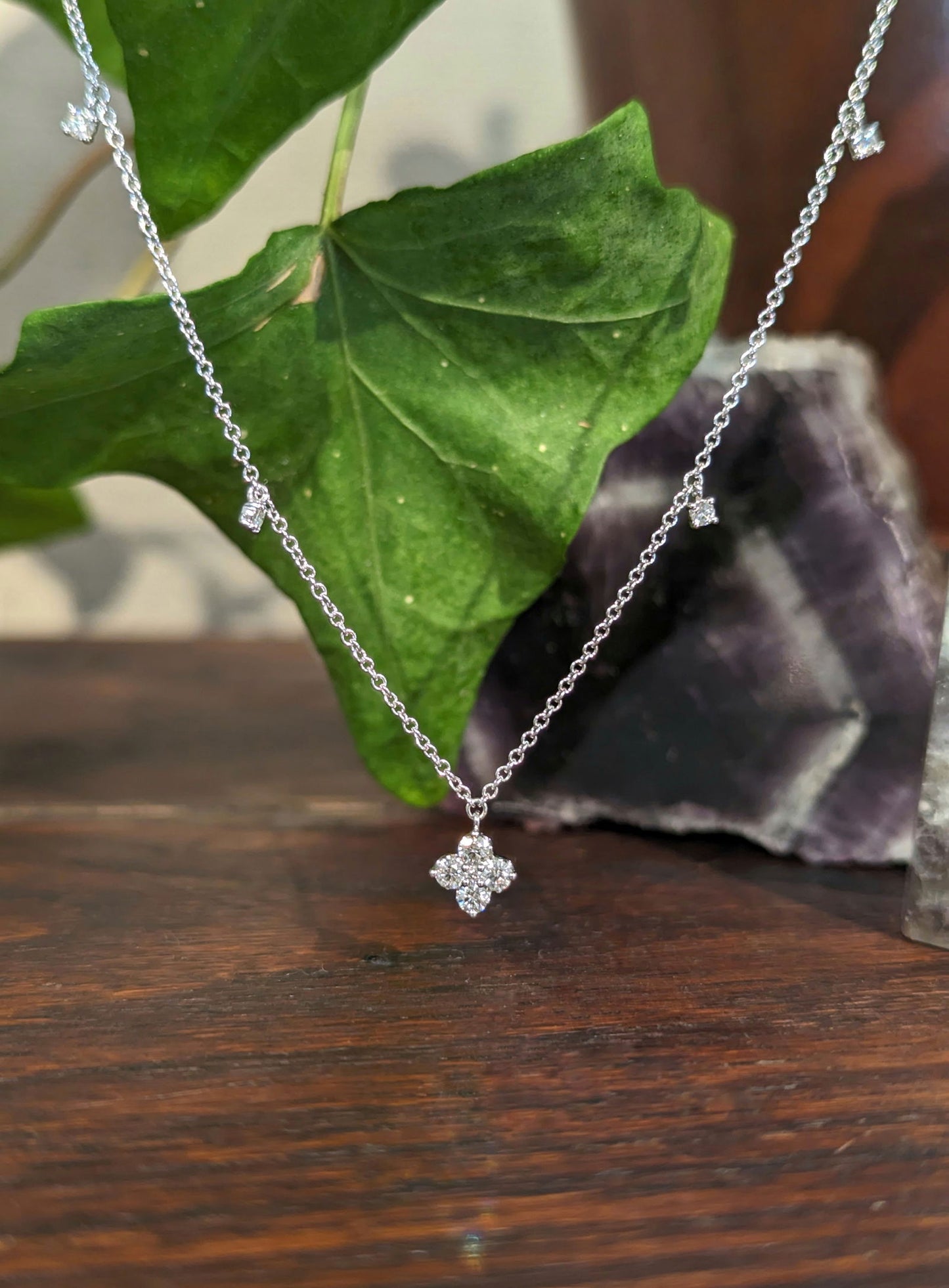 Photo of Dancing Diamond Quatrefoil Necklace in a decorative scene, designed by , available at Plumb Gold & Plumb Silver