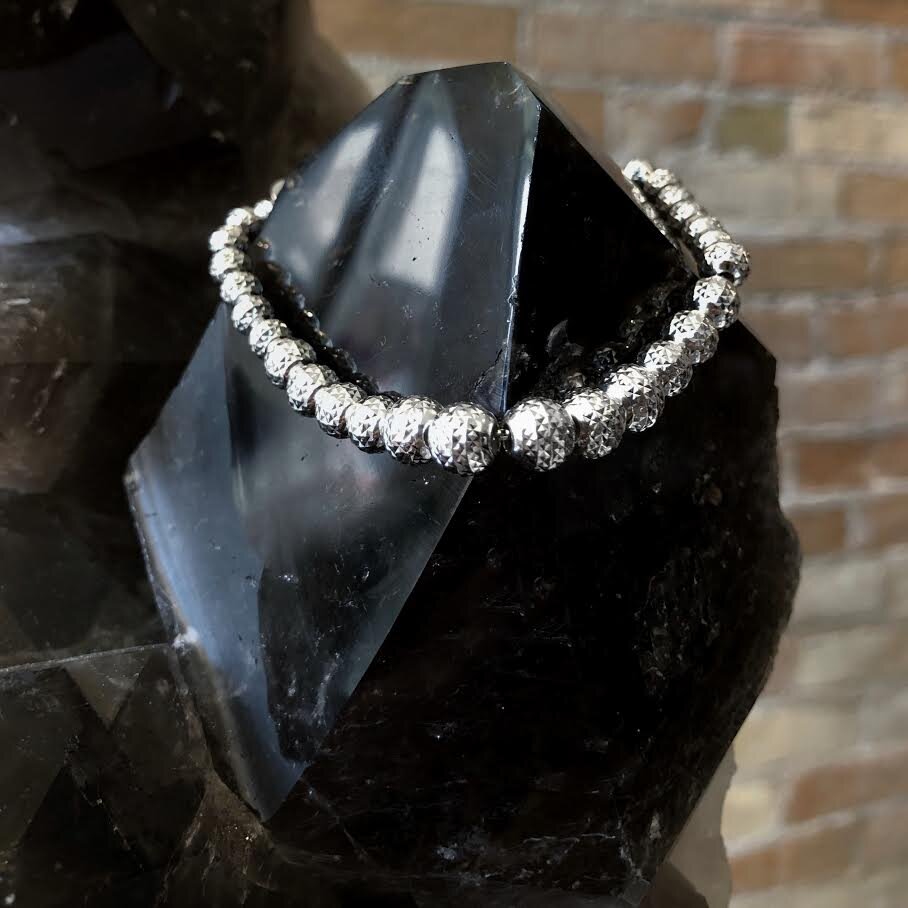 Photo of Diamond-Cut Bead Bracelet in a decorative scene, designed by , available at Plumb Gold & Plumb Silver