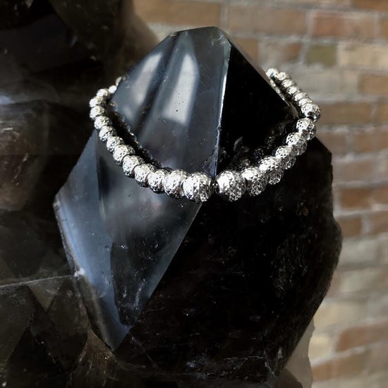 Photo of Diamond-Cut Bead Bracelet in a decorative scene, designed by , available at Plumb Gold & Plumb Silver