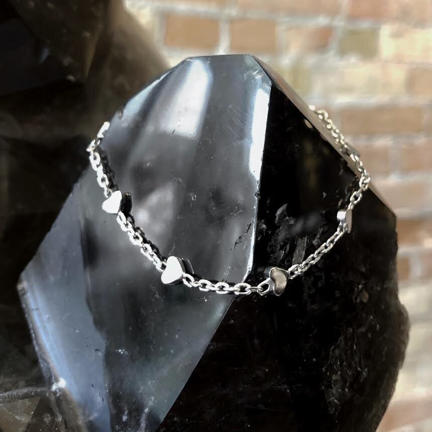 Photo of Diamond-Cut Heart Station Cable Bracelet in a decorative scene, designed by , available at Plumb Gold & Plumb Silver