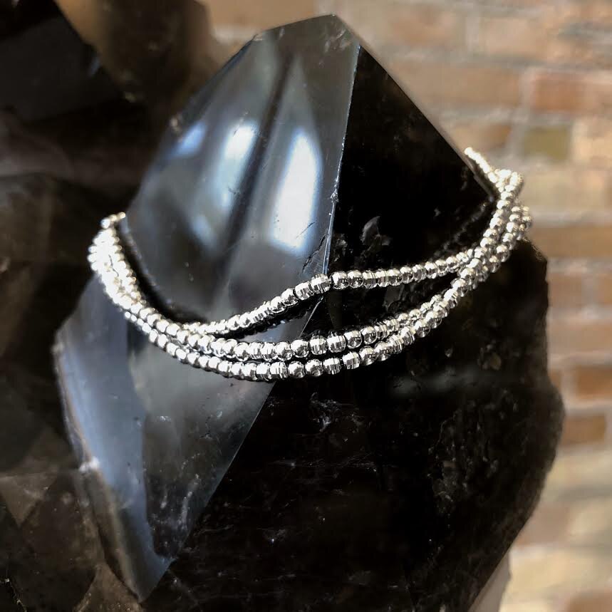 Photo of Diamond-Cut Multi-Strand Adjustable Bracelet in a decorative scene, designed by , available at Plumb Gold & Plumb Silver