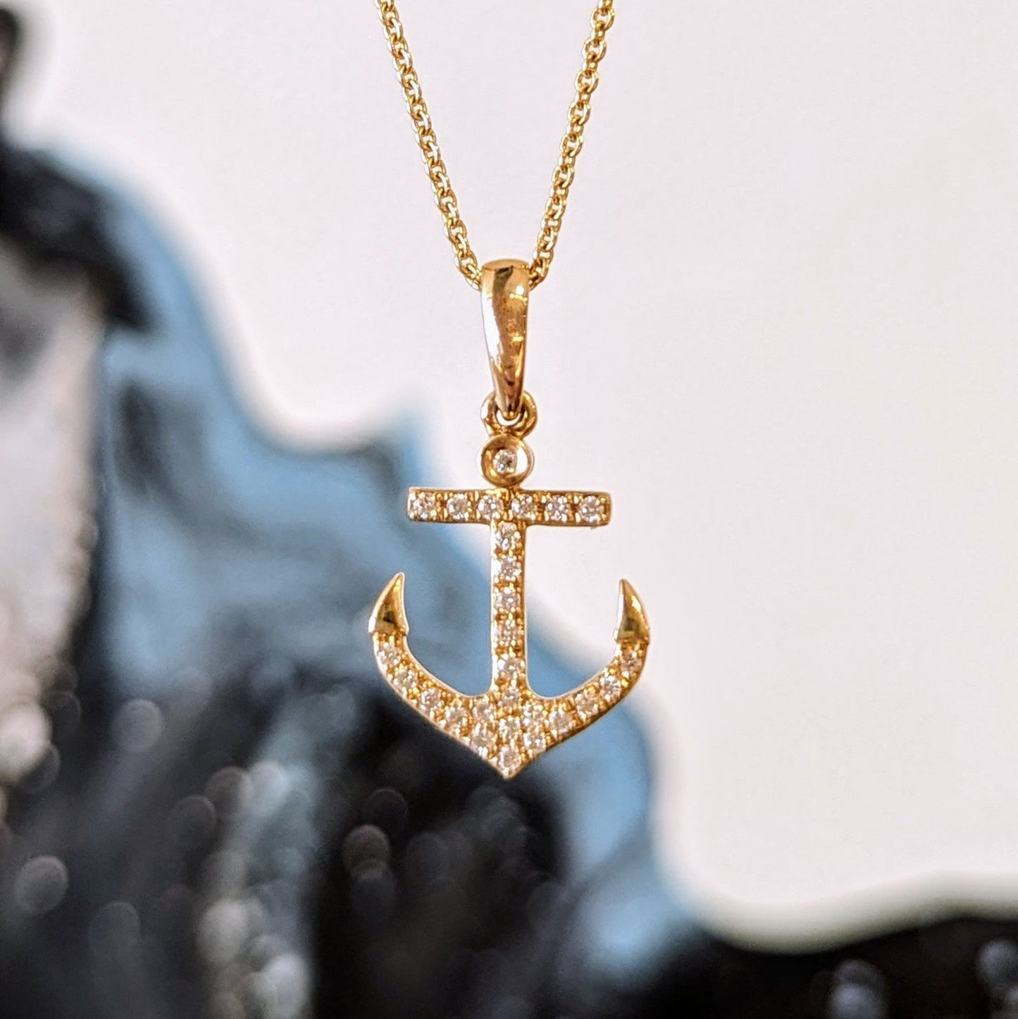 Photo of Diamond Anchor Necklace in a decorative scene, designed by , available at Plumb Gold & Plumb Silver