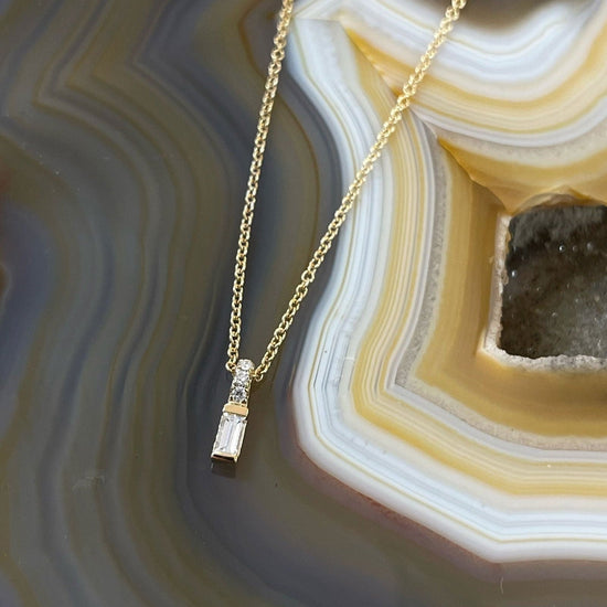 Photo of Diamond Baguette Necklace in a decorative scene, designed by , available at Plumb Gold & Plumb Silver
