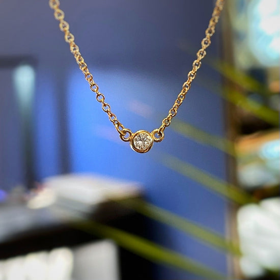 Photo of Diamond Bezel Necklace in a decorative scene, designed by , available at Plumb Gold & Plumb Silver